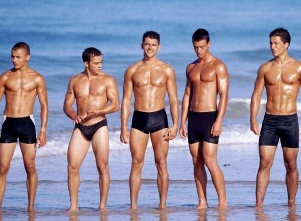 muškarci na plaži s povećanim pijetlovima